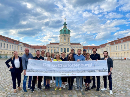 Menschen halten Banner mit Aufschrift Danke Charlottenburg vor dem Schloss Charlottenburg